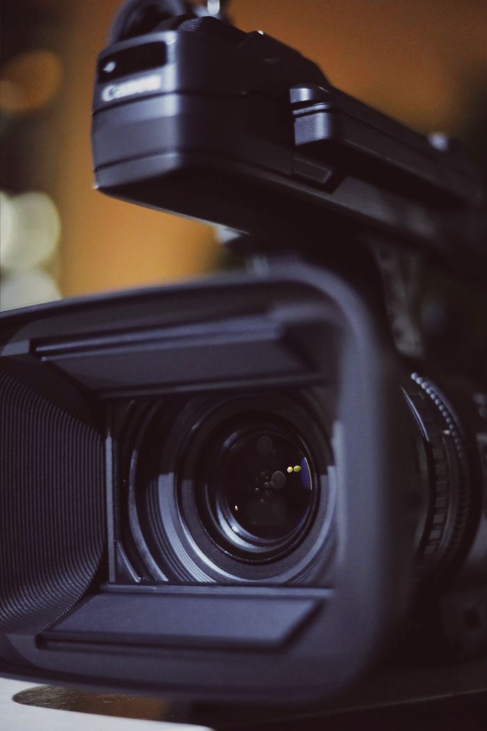 contact-img Detailed close-up of a professional video camera lens capturing focus and precision.